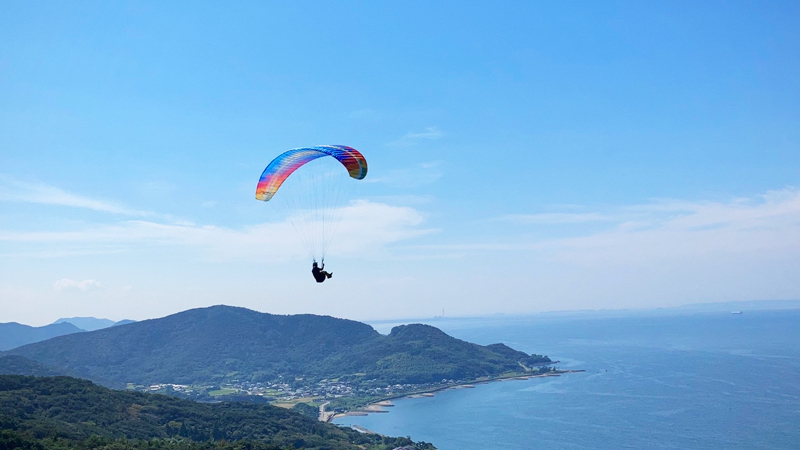パラグライダーと海と山