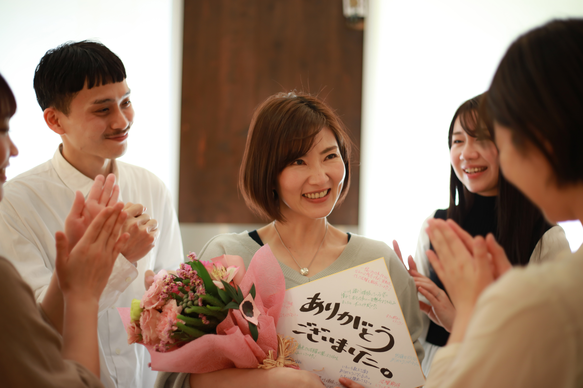 花束と色紙をもつ女性