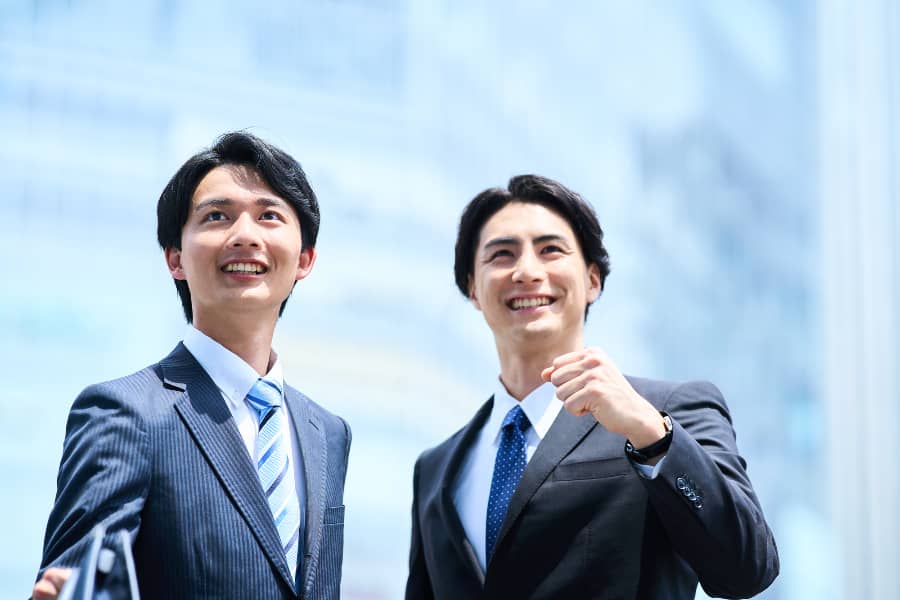 ガッツポーズのスーツの男性が2人